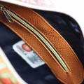 wnętrze torebki damskiej kuferek Chula z podszewką i kieszenią na zamek, brązowy materiał, widoczna metka z logo