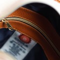 wnętrze torebki damskiej kuferek Chula z podszewką i kieszenią na zamek, brązowy materiał, widoczna metka z logo